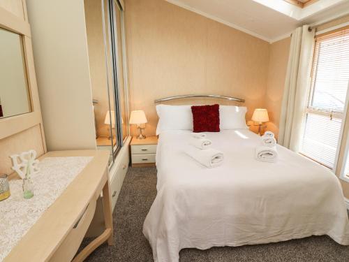 een slaapkamer met een groot wit bed en handdoeken bij 15 Silverbirch in Morpeth