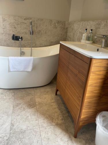 a bathroom with a tub and a sink at Private Guest Suite in Georgian Townhouse in City Centre in Edinburgh