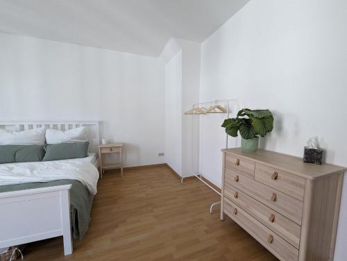 - une chambre avec un lit et une commode dans l'établissement Wohnung in Hallischer Innenstadt, à Halle-sur-Saale