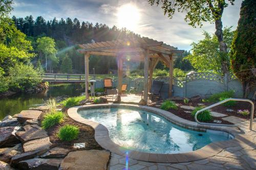 une piscine dans un jardin avec un kiosque dans l'établissement Auberge Du Vieux Moulin, à Sainte-Émélie-de-lʼÉnergie