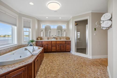 a large bathroom with a tub and a large mirror at Harbour View Haven in Stratford