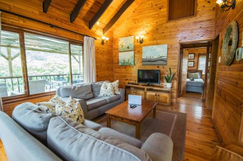 a living room with a couch and a tv at Thunzi Bush Lodge in Beach View