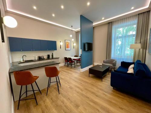 a living room with a blue couch and a kitchen at Golden Queen Apartments City Center in Krakow