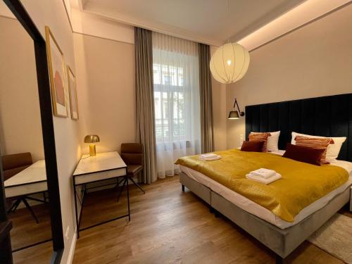 a bedroom with a large bed and a desk at Golden Queen Apartments City Center in Krakow