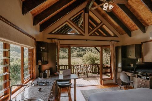 a kitchen with a view of a patio with a table at Thunzi Bush Lodge in Beachview