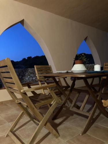 un tavolo e sedie in legno su un patio di Relax e tranquillità a Cala Pisana a Lampedusa