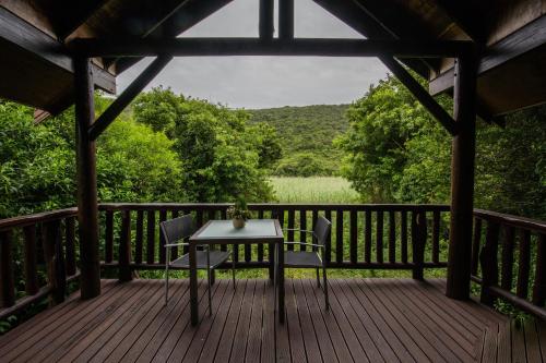 a wooden deck with a table and chairs on it at Thunzi Bush Lodge in Beachview