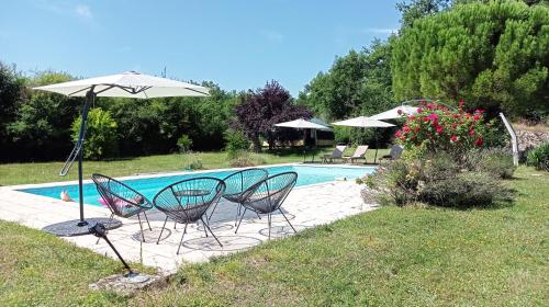- un groupe de chaises et un parasol à côté de la piscine dans l'établissement Yourte Maison Oya, à Montréal