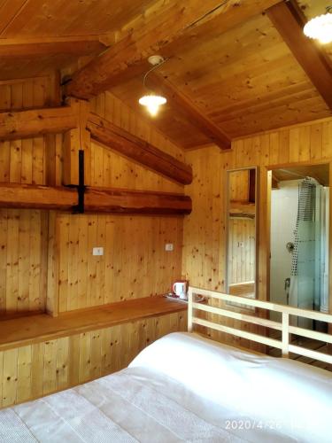 a bedroom with wooden walls and a large bed at Villa Belvedere Langhe in Belvedere Langhe