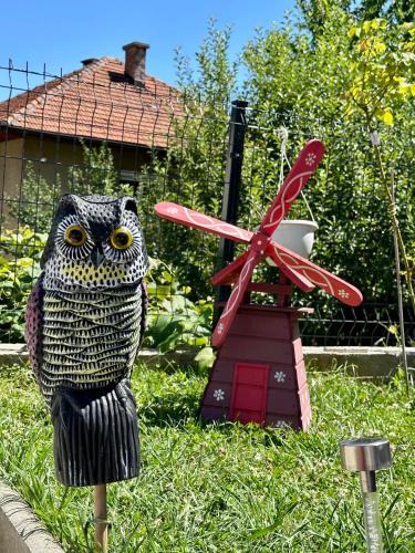 a statue of an owl sitting on a pole next to a windmill at Apartman Ejna in Sarajevo