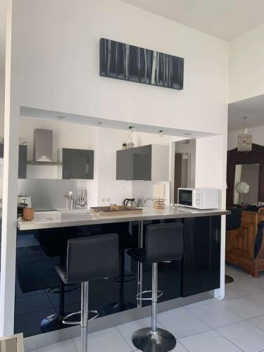 - une cuisine avec un comptoir avec des chaises et un four micro-ondes dans l'établissement Vivez en appartement en centre-ville - Hotel de ville - 1 ch, au Havre