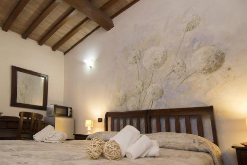 a bedroom with a bed with a painting on the wall at La Locanda Di Giada e Giorgia in Pisa