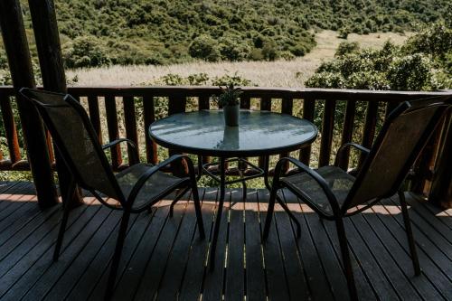 a table and two chairs on a deck at Thunzi Bush Lodge in Beachview
