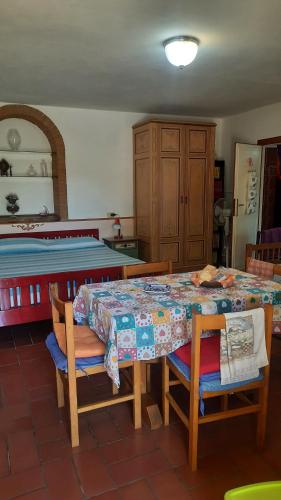 テッラヌオーヴァ・ブラッチョリーニにあるArtenatura BeBのテーブル、椅子、ベッドが備わる客室です。