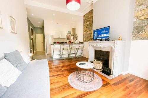 - un salon avec une cheminée et un canapé blanc dans l'établissement #G3 The authentic T2 downtown Balcony tramway, à Grenoble