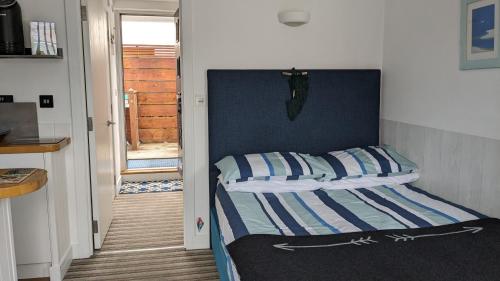 a bedroom with a bed with blue and white stripes at Studio 2 in Newquay