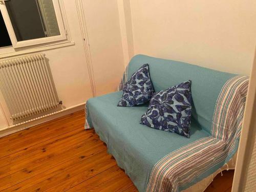 a green couch with two pillows on it in a room at Appartement lumineux Vue montagne Centre Grenoble in Grenoble