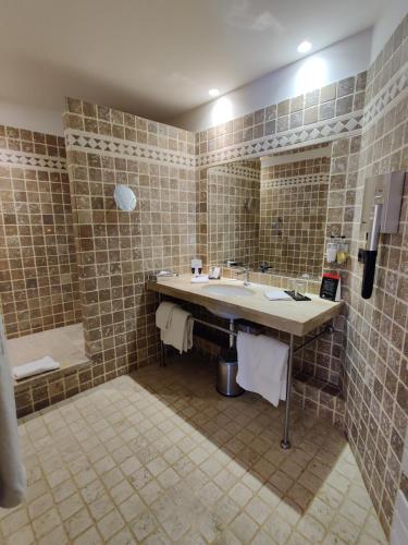 a bathroom with a large sink and a shower at Hôtel de Bourgtheroulde, Autograph Collection in Rouen