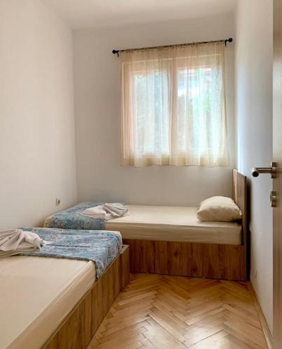 twee bedden in een kamer met een raam bij Central City Apartment in Skopje