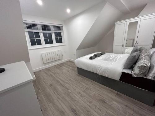 a white bedroom with a bed and a window at stunning cinematic 2 bed in Hendon