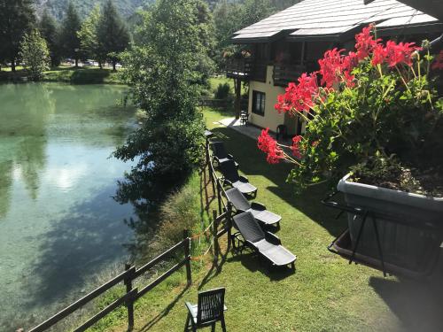 a row of benches sitting next to a lake at Hotel Cà Fiore in Bardonecchia