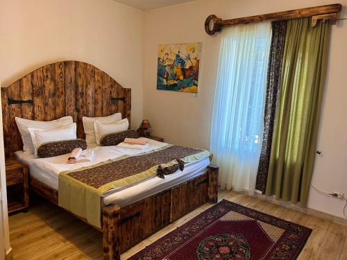 a bedroom with a large bed with a wooden headboard at Machanents Art Hotel in Vagharshapat