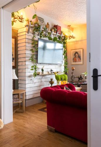 a living room with a red couch and a window at James' Place at The Park in Merthyr Tydfil