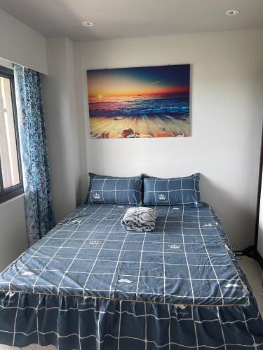 a bed in a bedroom with a painting on the wall at Ma Roberta @ Tambuli Resort with fast WIFI in Maribago