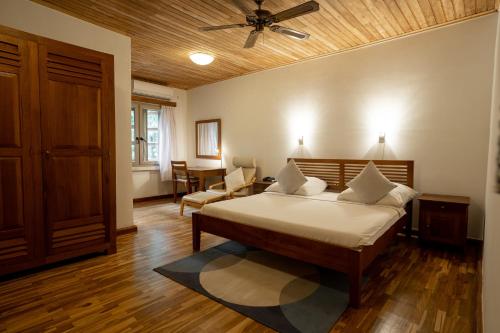 a bedroom with a bed and a ceiling fan at Esther's Hotel in Accra