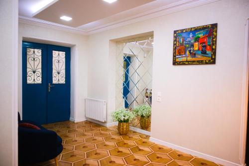 a hallway with a blue door and a painting on the wall at Metekhi View Hotel in Tbilisi City
