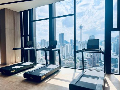 a gym with two treadying machines in front of a window at Axon Serviced Suites Kuala Lumpur in Kuala Lumpur
