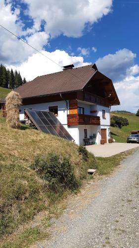 a house with a solar panel next to a road at Ferienwohnung Stampfer in Gnesau