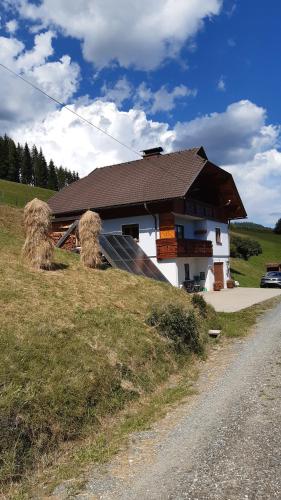 a house on a hill with hay bales at Ferienwohnung Stampfer in Gnesau