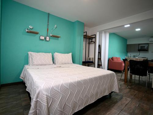a bedroom with a large bed with a blue wall at CoLinkHouse Hotel in Medellín