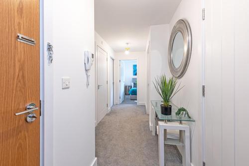 a hallway with a table and a mirror on a wall at Gospel Heights by Guestz in Heswall