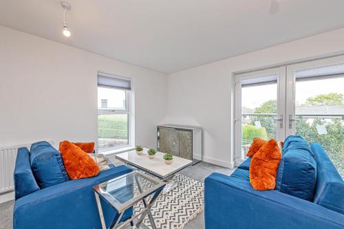 a living room with two blue couches and a table at Gospel Heights by Guestz in Heswall