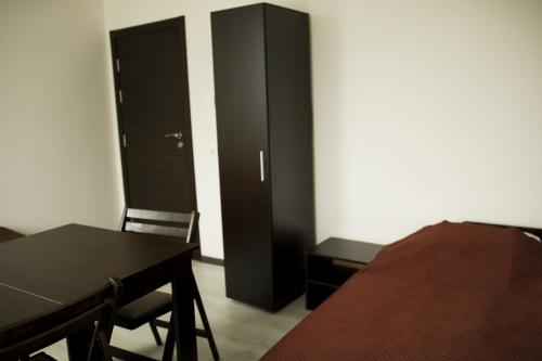 een slaapkamer met een zwarte kast en een tafel en stoelen bij Private Rooms Kranevo in Kranevo