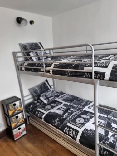 two metal bunk beds in a room with a bed sidx sidx at Legiteducerf 3 étoiles in Sengouagnet