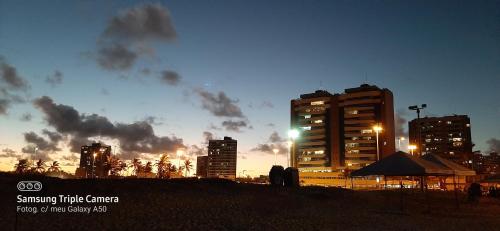 un perfil urbano con edificios altos y puesta de sol en Apto na Praia de Atalaia a 100 metros da Passarela do Caranguejo en Aracajú