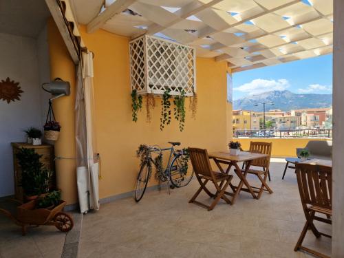 a patio with a table and a bike on the wall at Caletta sul Mare in La Caletta