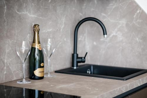 a bottle of champagne sitting on a counter next to two wine glasses at Hotel Luciana in Bibione