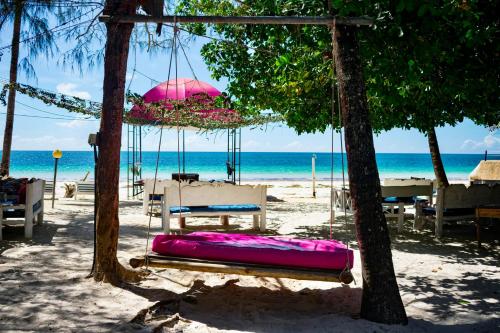 a swing on the beach with the ocean in the background at Soul Breeze Beach Resort in Diani Beach
