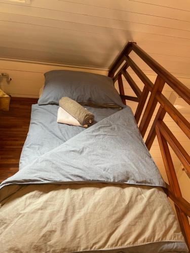 a bed with a wooden frame with a towel on it at Bungalov na vode - Lobster in Senec