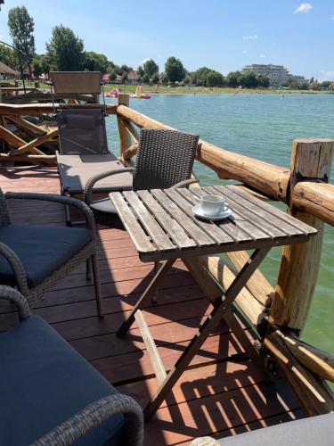 a wooden table and chairs on the deck of a boat at Bungalov na vode - Lobster in Senec