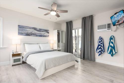 a white bedroom with a bed and a ceiling fan at Ocean Flats 3 - Lauderdale-by-the-Sea in Fort Lauderdale