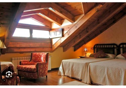 een slaapkamer met een bed, een stoel en een raam bij Hotel la posada de Numancia in Garray