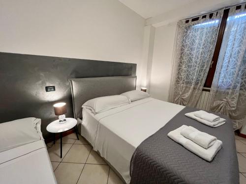 a bedroom with a large white bed and a window at Residence la Lucciola in Lonato