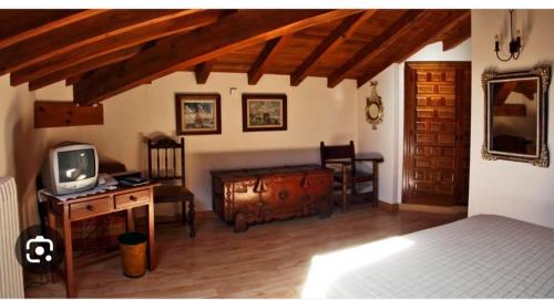 a bedroom with a bed and a desk with a tv at Hotel la posada de Numancia in Garray