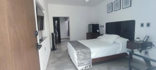 a bedroom with a white bed and a glass table at La Casa Mia Leon in León