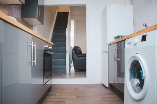 a laundry room with a washing machine and a staircase at Nicely made relaxing 4 Bedroom near LFC Stadium in Liverpool